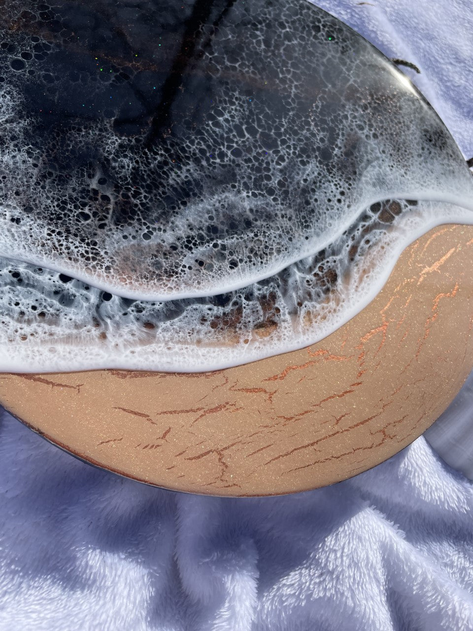 Moody black resin ocean and waves with shimmering copper beach
