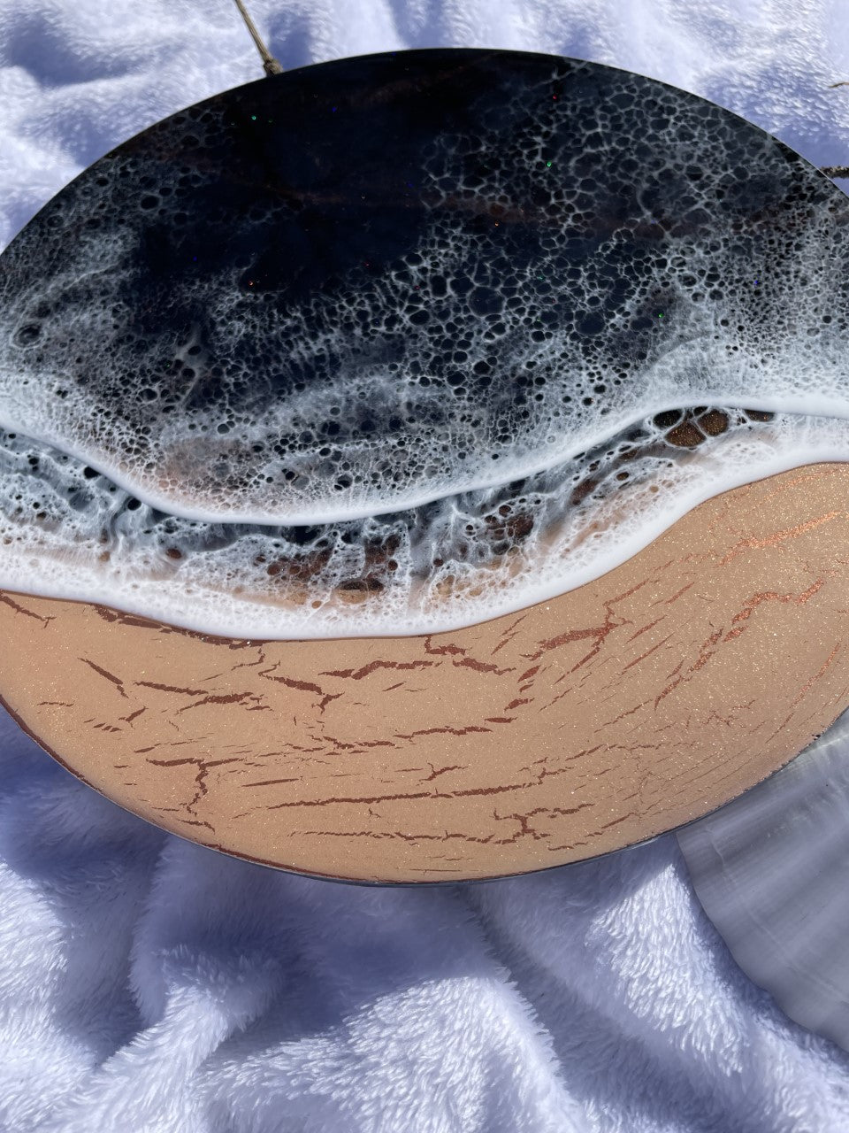 Moody black resin ocean and waves with shimmering copper beach