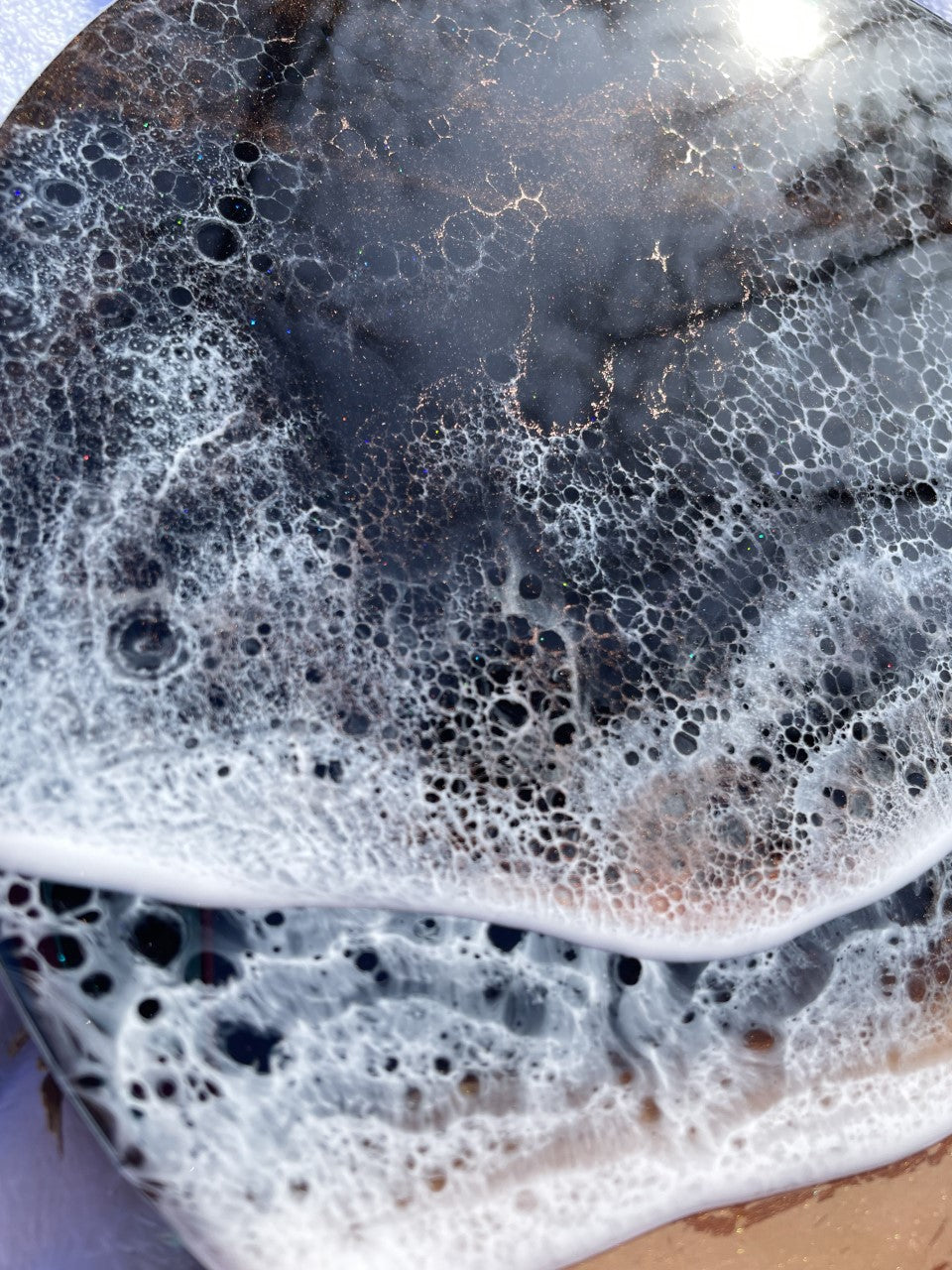 Moody black resin ocean and waves with shimmering copper beach